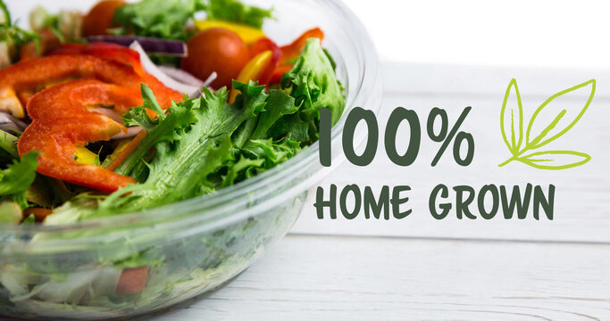 Image of 100 percent home grown text in green over bowl of fresh salad on white boards