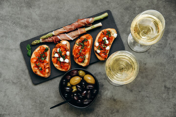 Snacks in the restaurant bruschetta with tomatoes and asparagus with prosciutto and olives two...