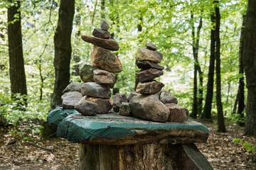 stones stacked in forest with mostly green background