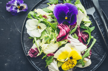 Healthy salad with green and purple lettuce and edible flowers