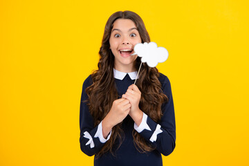 Teenager child girl holding thinking bubble, comment cloud over yellow background.