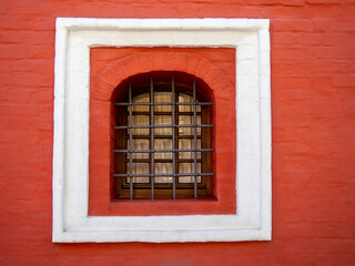 Retro window on the old red wall.