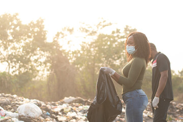 african man and woman cleaning a refuse site