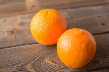 Two fresh organic orange on a wooden table