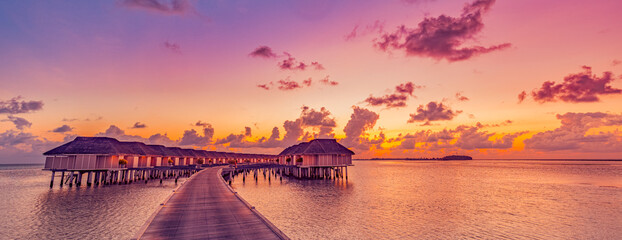 Amazing tropical sunset panorama at Maldives islands. Luxury resort villas seascape with soft led...