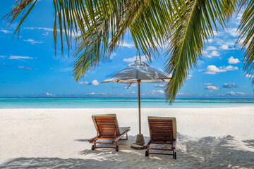 Fototapeta na wymiar Beautiful tropical island, two chairs, umbrella under palm tree leaves, paradise sea sand sky. Summer travel landscape, vacation beach scenic, idyllic exotic nature closeup of recreation, relaxation. 