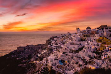 Sunset night view of traditional Greek village Oia on Santorini island in Greece. Santorini is iconic travel destination in Greece, famous sunset point landscape and traditional white architecture