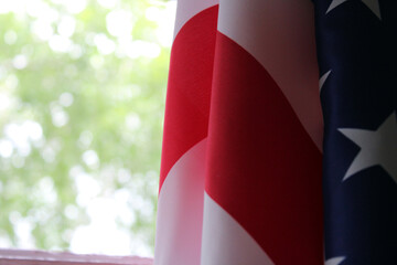 The U.S. flag hangs against a background of green foliage. Flag Day. Memorial Day. Independence Day. © IronG96