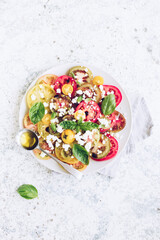 Obraz na płótnie Canvas Tomato salad with basil, feta cheese and olive oil