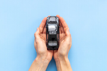 Car insurance or driving safety concept. Toy car in hands