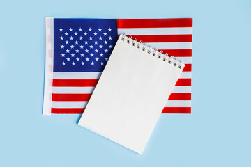 American flag with open notebook or list on blue background. United states, USA flag. Happy Independence day, memorial day, fourth 4th of july concept. Flat lay, top view, place for text