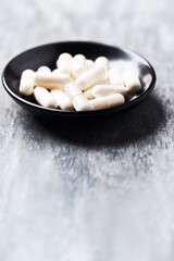 Beta-alanine capsules. Bodybuilding food supplements on wooden background. Close up. Copy space.	