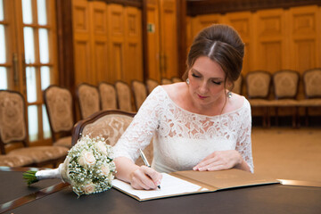 A beautiful 40 year old bride signs in a marriage registration book