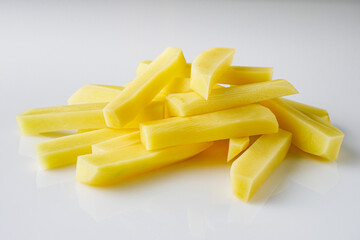peeled potatoes sliced for french fries on a white background