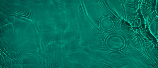Transparent dark green clear water surface texture with ripples and splashes. Abstract summer...