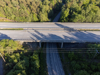 Aerial view of highway, viaduct, roads, lanes with no cars. Drone photography taken from above in Sweden in summer. Surroundings with trees, forest. Travel, transportation concept.