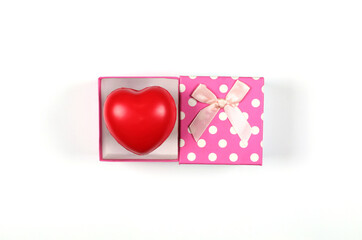 Pink gift boxes with red hearts with ribbon bows placed on a white background. Gift box top view image has copy space.