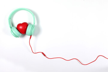 Green headphone with red heart isolated on white background, flat lay photography have copy space.