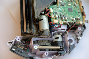 Parts and the board of the robot vacuum cleaner in disassembled form. Repair of robots.