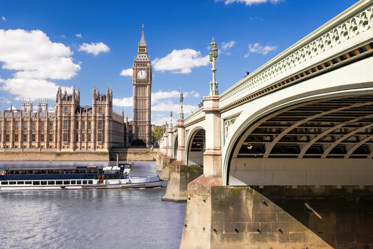 Famous Big Ben with bridge over Thames and tourboat on the river in London, England, UK