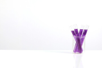 Test tube with purple liquid is placed on a table and white background. Scientific research