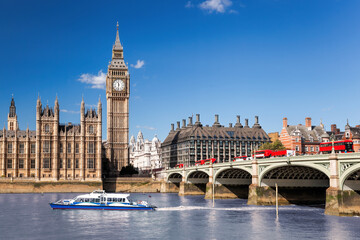 Famous Big Ben with bridge over Thames and tourboat on the river in London, England, UK - 509354596