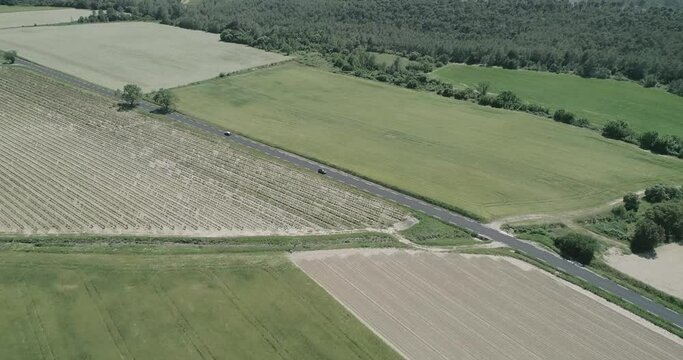 Aerial view of green fields and dry, surrounded by hills, plants and mountains