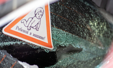 Warning sign on a car window. Translation: Child in the car. War of Russia against Ukraine. A car of civilians shot by the Russian military during the evacuation of women and children.
