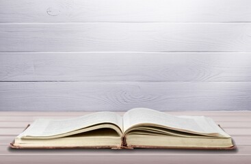 Open book on old wooden table.