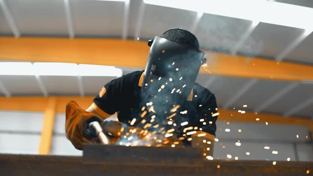 Professional Heavy Industry Welder working in industrial production factory. welding worker wearing helmet. Industrial Process, Heat Electrode Work. Metalwork Assembly, Construction