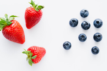Top view of strawberries and blueberries on white background.