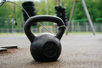 Naklejka na ściany i meble Close-up of kettlebell on an outdoor sports field. Selective focus on sports equipment for weightlifting