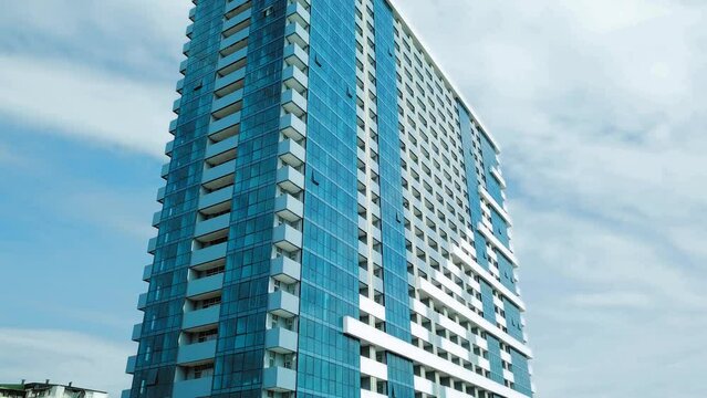 Newly built building. Part of modern residential apartment with exterior of flat building. Detail of New elite house and home complex. Fragment of urban real estate and condominium architecture.