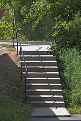 Concrete stairs in the alley of the city park on a summer day