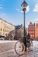 Bicycle leaning against a lamppost in Stockholm Gamla Stan. Bike parked in a cobbled square in...
