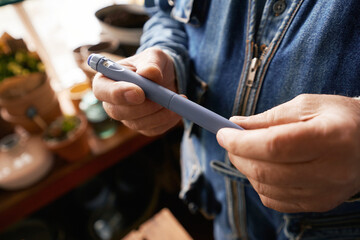 Man holding insuline pen in flower shop