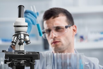 Woman chemist holds flask with liquid in hands in the chemical laboratory. Quality control of petrochemical products concept.