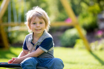 Blond child, playing with a pop up toy in the garden, antistrees silicone toy