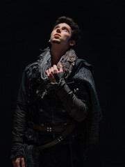 A guy in a steampunk or post-apocalyptic image, looking up, the overhead light on his face. a moment of calm.