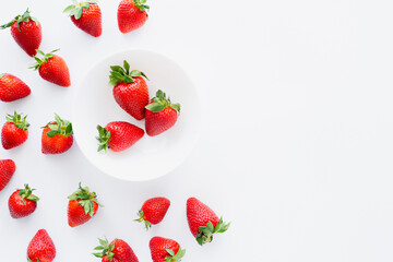 Top view of tasty strawberries in plate on white background.