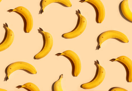 Yellow bananas pattern on a trendy beige background. Summer freshness, natural snack, organic. Healthy eating, raw food, vegan vitamins food concept. Bright abstract backdrop or wallpaper