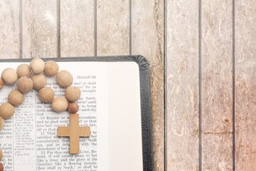Christian wooden cross and Bible on table