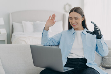 Young disabled woman has conference online on laptop. Remote work for handicapped girl.