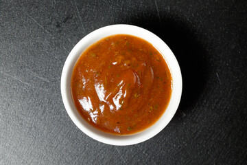 Wine honey sauce in bowl on a slate slab on black background