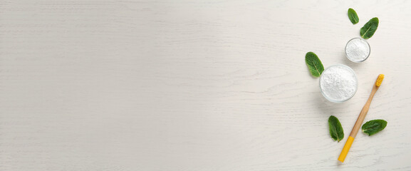 Tooth powder, brush and mint on white wooden table, flat lay with space for text. Banner design