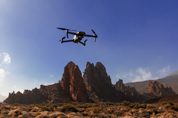 Fototapeta na wymiar Folding small drone is flying over the mountains.