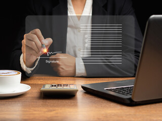 Electronic signature. A businesswoman uses a pen to sign electronic documents on digital documents...