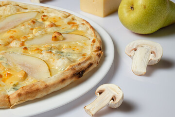 Tasty pizza with pear and cooking ingredients with kitchen toolson white background