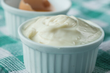 close up of Mayonnaise in container on table .