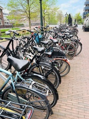 Many different bicycles parked on sidewalk, closeup
